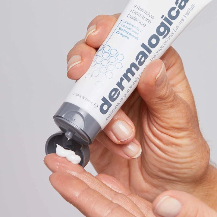 Dermalogica Intensive Moisture Balance 50 ml ansigtscreme trykkes ud af hvid tube med gråt låg