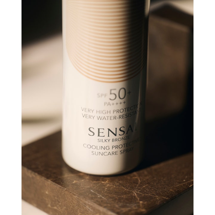 Sensai Silky Bronze Cooling Protective Suncare Spray 150 ml vandfast solspray med SPF 50+ på mørk marmoroverflade.