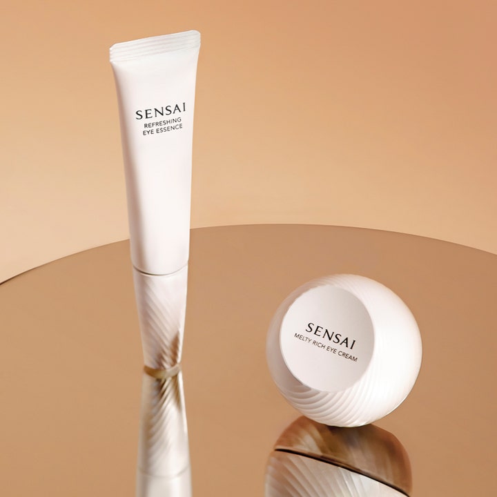 Sensai Refresh Eye Essence Refill 20 ml opfriskende øjenpleje i hvid tube og krukke på spejlende guldoverflade