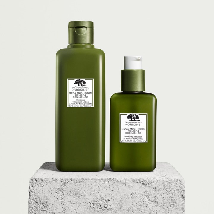 Origins Mega-Mushroom Relief & Resilience 200 ml beroligende ansigtspleje i grønne flasker på en rå stenblok