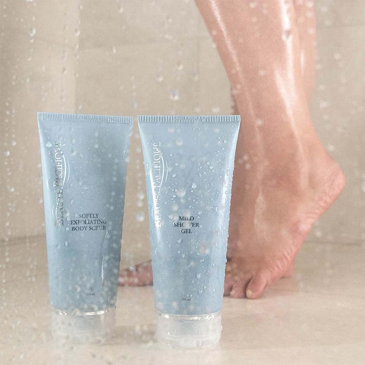 Beauté Pacifique Mild Shower Gel 200 ml i lyseblå tube vist i en bruser med vanddråber for en frisk følelse