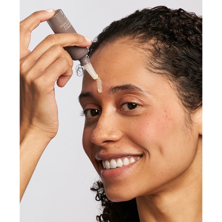 Exuviance Wrinkle Smooth Topical Peptide 5 g serum mod rynker påføres i panden fra en lille grå tube.