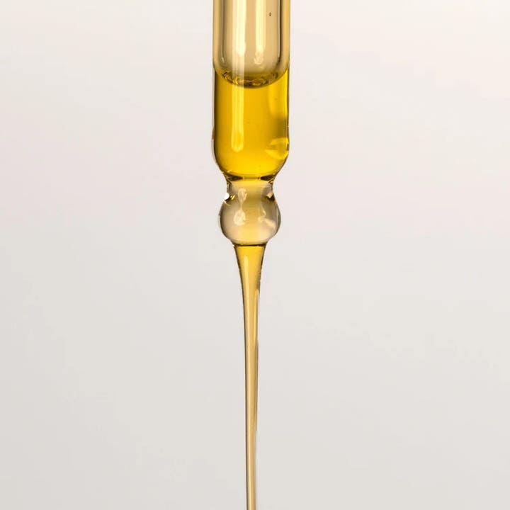 Codage Paris Relaxing Oil 100 ml beroligende kropsolie viser en flydende gylden tekstur fra en glaspipette