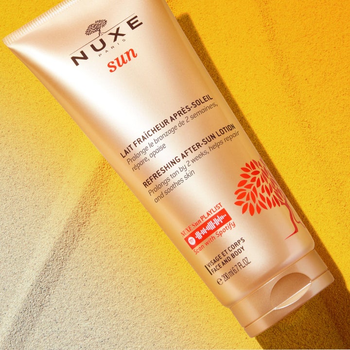 Nuxe Sun Refreshing After Sun Lotion 200 ml after sun i gylden tube på sand der forlænger kuløren
