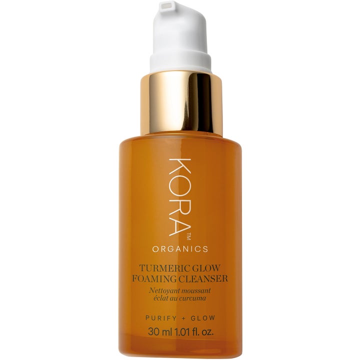 Kora Organics Turmeric Glow Foaming Cleanser 30 ml glødgivende ansigtsrens i ravfarvet flaske med guldtop og hvid pumpe
