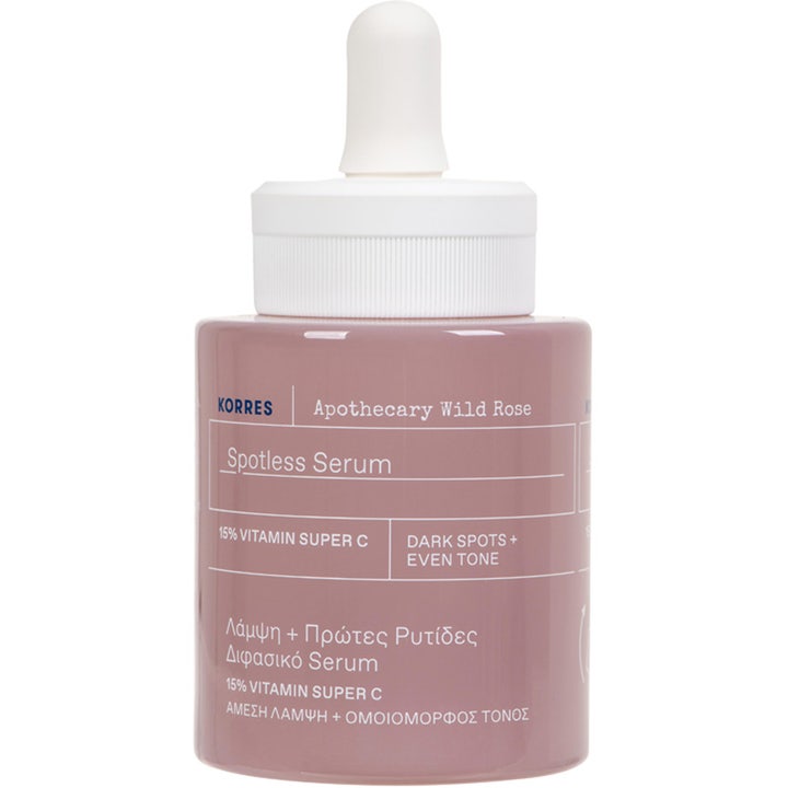 Korres Apothecary Wild Rose Spotless Serum 30 ml mod mørke pletter i en støvet lyserød glasflaske med hvid pipette.