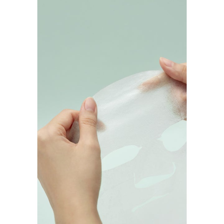 I'm from Vitamin Tree Sheet Mask 1 stk fugtgivende ansigtsmaske i hvidt tekstil holdt af hænder