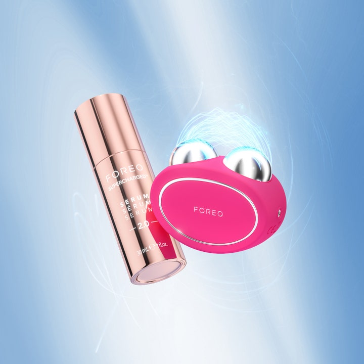 FOREO BEAR 2 Fuchsia 1 stk opstrammende beauty tech vist med rose guld serum flaske og blå lyseffekter