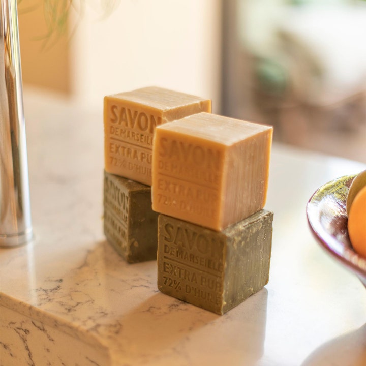 Compagnie de Provence Cube Of Marseille Soap Olive 400 g plejende håndsæbe med rustikke grønne sæbeblokke på hvid marmor