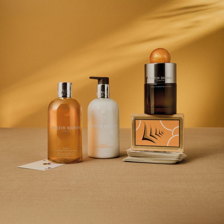 Molton Brown Sunlit Clementine & Vetiver Bath & Shower Gel 300 ml i et varmt gyldent miljø med matchende kropspleje