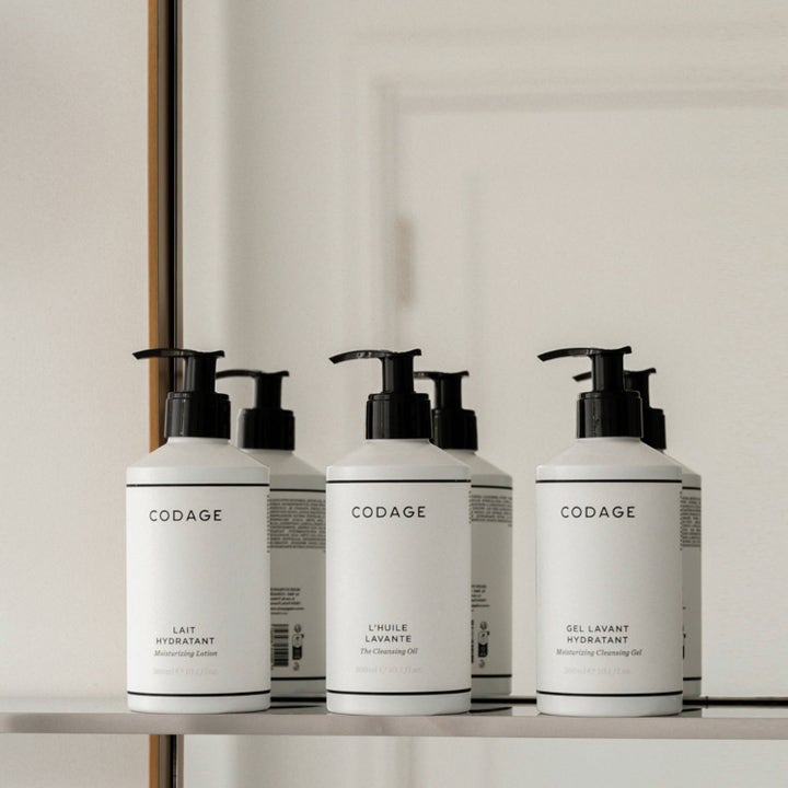 Codage Paris The Moisturizing Cleansing Gel 300 ml fugtgivende brusegel i hvide flasker med sorte pumper foran spejl