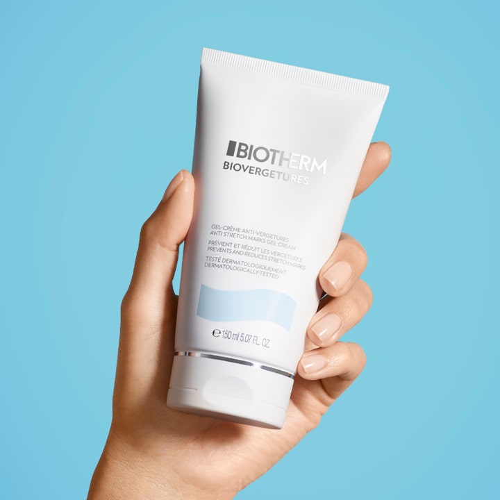 Biotherm Biovergetures 150 ml creme mod strækmærker i hvid tube holdt af en hånd mod en lyseblå baggrund