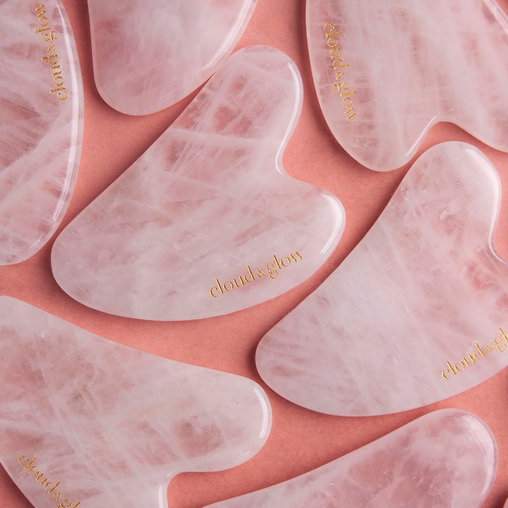 Cloud & Glow Rose Quartz Gua Sha 1 stk hudplejeværktøj i lyserød sten med guldlogo giver huden fornyet glød.