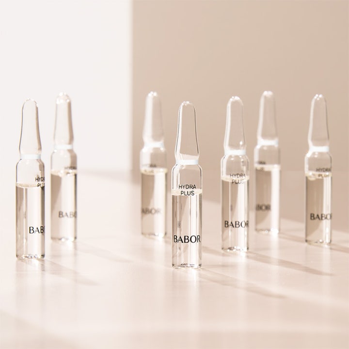 Babor Ampoule Hydra Plus 14 ml fugtgivende serum i syv klare glasampuller stående i blødt lys