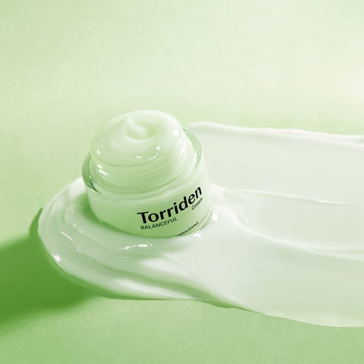 Torriden BALANCEFUL Cica Cream 80 ml beroligende ansigtscreme i krukke placeret på en blød lysegrøn geltekstur