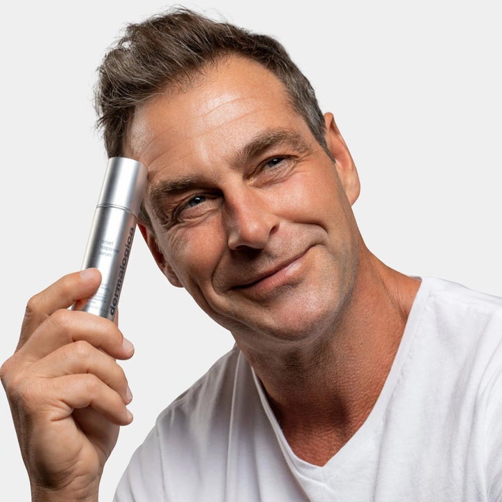 Dermalogica Smart Response Serum fugtgivende ansigtsserum mand der holder sølvfarvet pumpeflaske mod panden