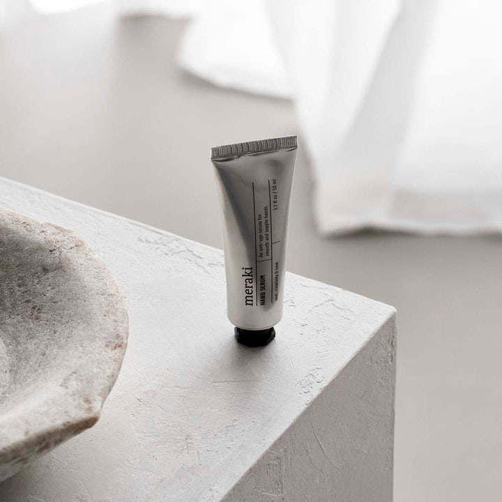 Meraki Hand Serum 50 ml anti-age håndpleje i sølvfarvet tube der giver bløde hænder på en lys stenoverflade