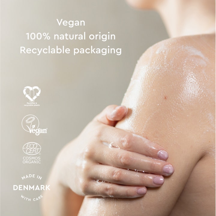 Urtekram Soothing Lavender Body Wash 500 ml vegansk duschtvål påføres på huden med tekst om 100% naturlig oprindelse.