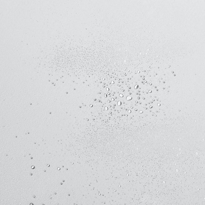 Dermalogica UltraCalming Mist Duo beroligende ansigtsspray med tekstur af fine vanddråber på en lys baggrund.
