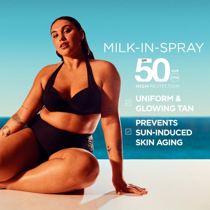 Garnier Ambre Solaire Ideal Bronze Milk-in-Spray 150 ml solcreme giver jævn glød vist med kvinde ved havet og SPF 50