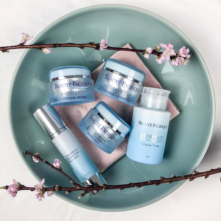 Beauté Pacifique Superfruit Day Cream Dry Skin 50 ml fugtgivende dagcreme i lyseblå krukke på fad med blomster.