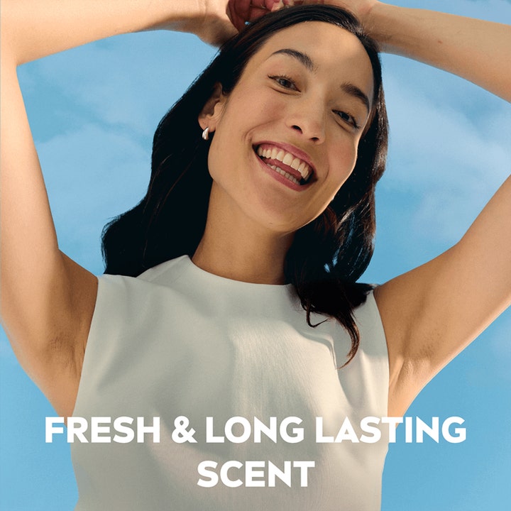 NIVEA Deo Rollon Dry Comfort 50 ml giver fresh & long lasting scent vist med en smilende kvinde mod en blå himmel