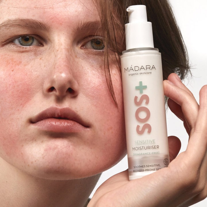MÁDARA SOS + SENSITIVE Moisturiser 50 ml beroligende ansigtscreme i hvid pumpeflaske vist ved ansigt