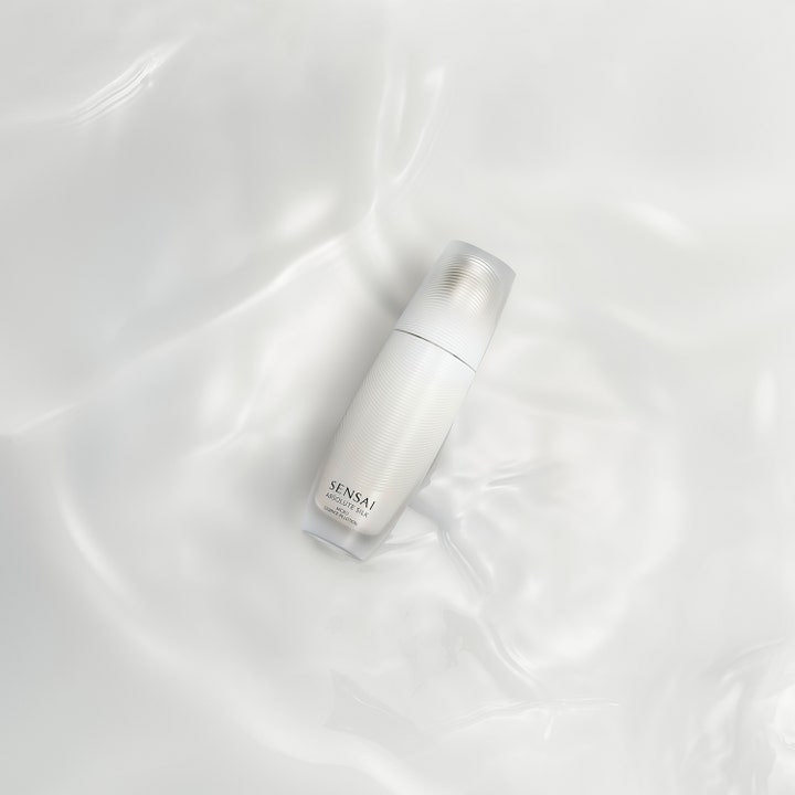 Sensai Absolute Silk Micro Essence-In-Lotion 125 ml serum i hvid flaske på en silkeblød vandoverflade