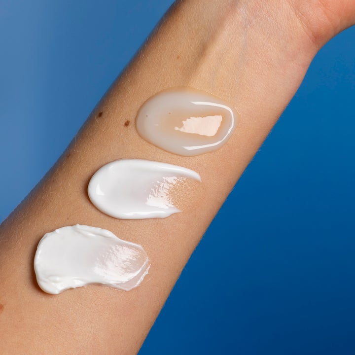 Lumene Nordic Hydra Moisture Balm 50 ml fugtgivende dagcreme med tre cremede teksturer på en arm mod blå baggrund