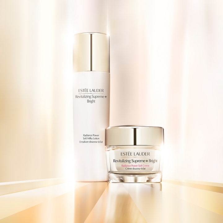 Estée Lauder Revitalizing Supreme+ Bright 50 ml ansigtscreme og lotion i hvide flasker med guldskær og lysende glød.