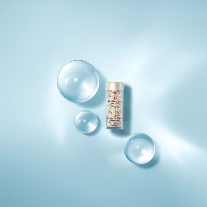 Elizabeth Arden Ceramide Capsules Hyaluronic Acid + Peptides 28 ml fugtgivende serum med vandbobler på blå baggrund.