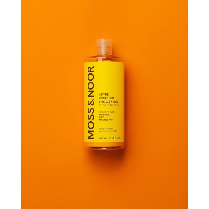 Moss & Noor After Workout Shower Gel 500 ml i gennemsigtig flaske med gul label mod orange baggrund