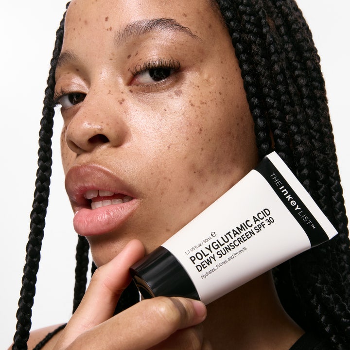The INKEY List Polyglutamic Acid Dewy Sunscreen SPF30 50 ml i hvid tube holdt af model med glødende hud