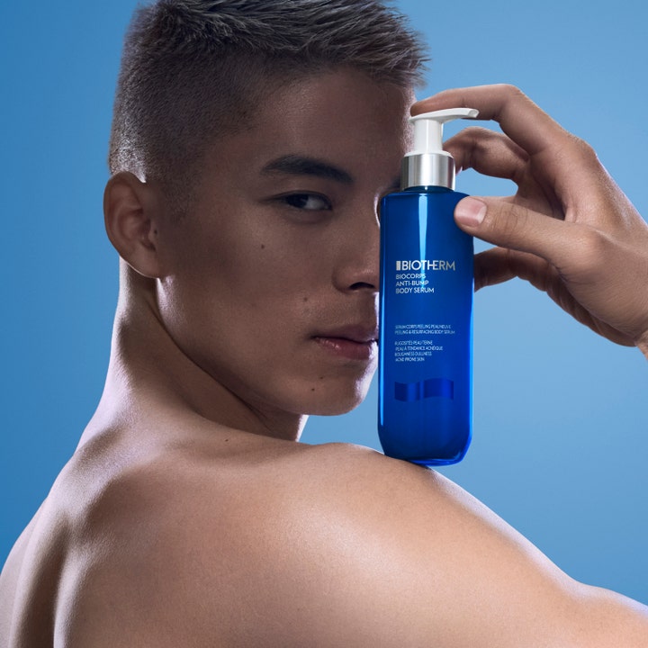 Biotherm Biocorps Anti-Bump Body Serum 200 ml mod urenheder i blå pumpeflaske holdt af en mand