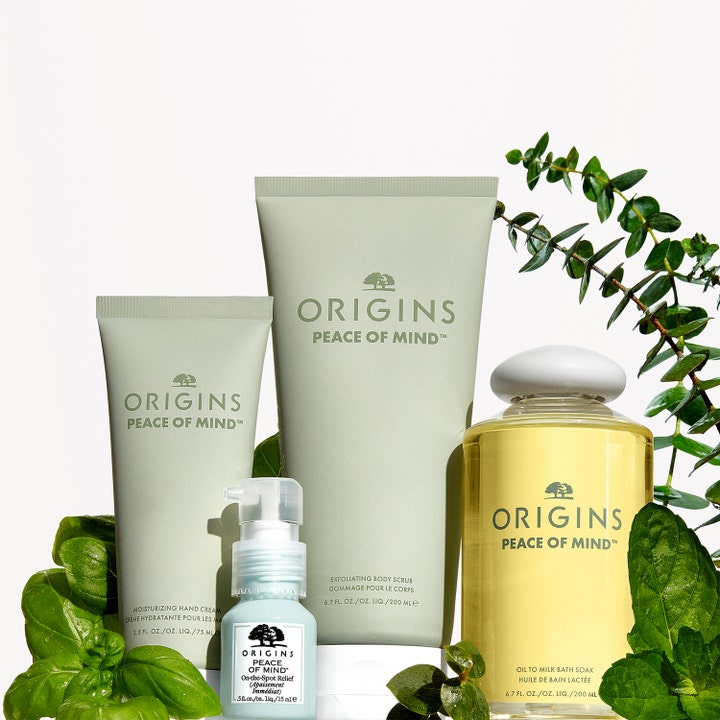 Origins Peace Of Mind Moisturizing Hand Cream 75 ml fugtgivende håndcreme i tube vist med kropspleje og grønne blade