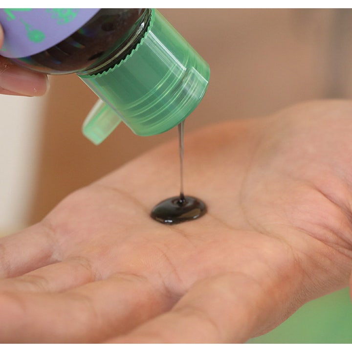 Chasin' Rabbits Mindful Bubble Cleanse 200 ml rensende ansigtsrens med sort gel der hældes fra en grøn flaske i en hånd.