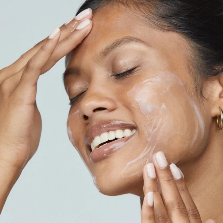 Dermalogica UltraCalming Cleanser 500 ml beroligende ansigtsrens i cremet gelform påført på en kvindes ansigt.