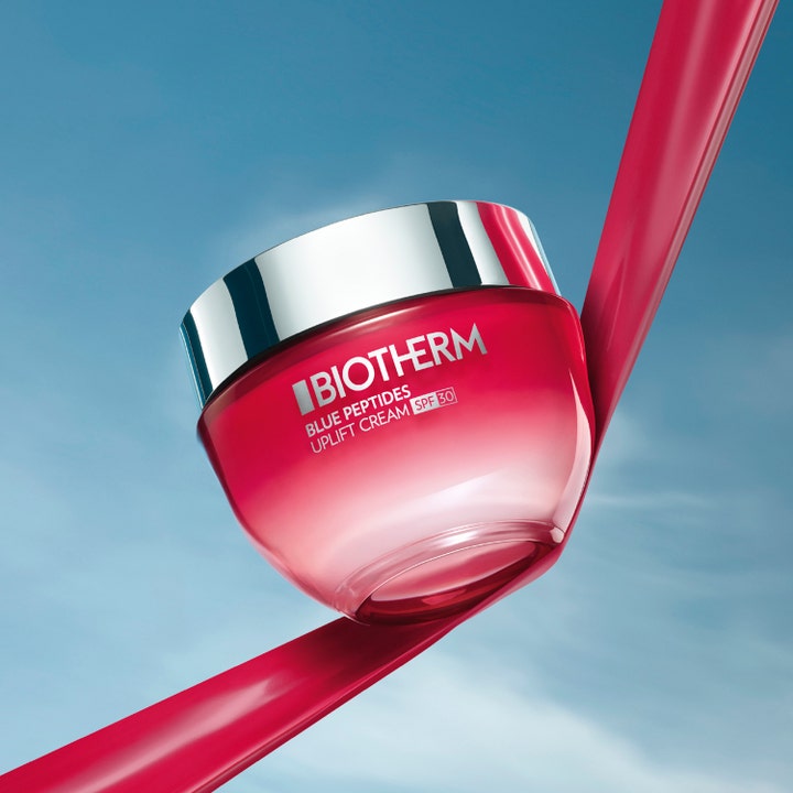 Biotherm Blue Peptides Uplift Cream SPF30 50 ml opstrammende ansigtscreme i pink glaskrukke mod blå himmel