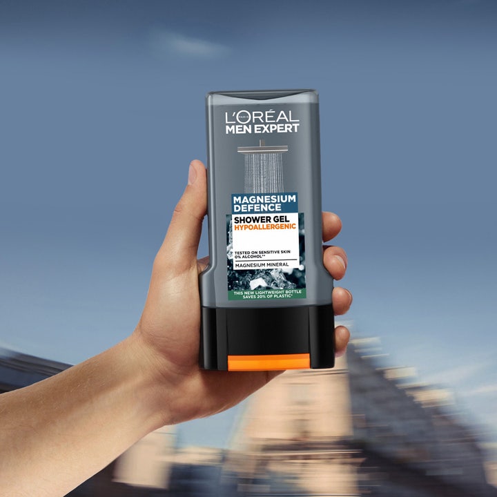 L'Oréal Paris Men Expert Magnesium Defence 300 ml showergel til sensitiv hud i en grå flaske holdt af en hånd.