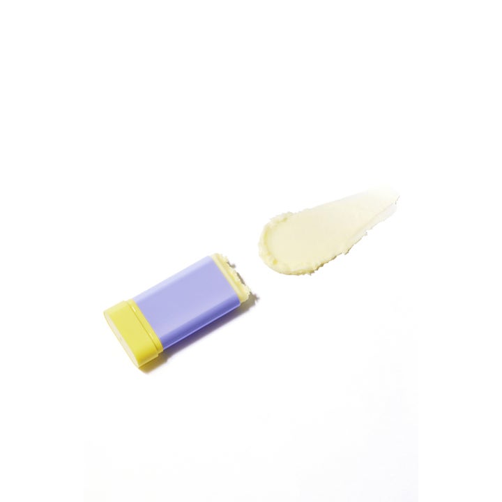 By Wishtrend Pore Smoothing Bakuchiol Sun Stick 18 g solcreme stift i lilla og gul med cremet lysegul tekstur.