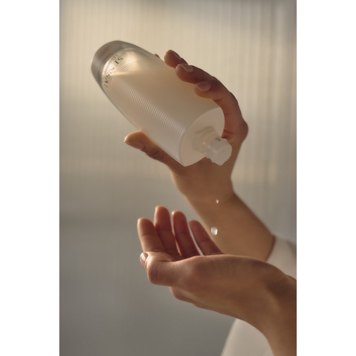 Sensai Absolute Silk Micro Essence-In-Lotion 125 ml serum hældes ud i hænderne som klare dråber.