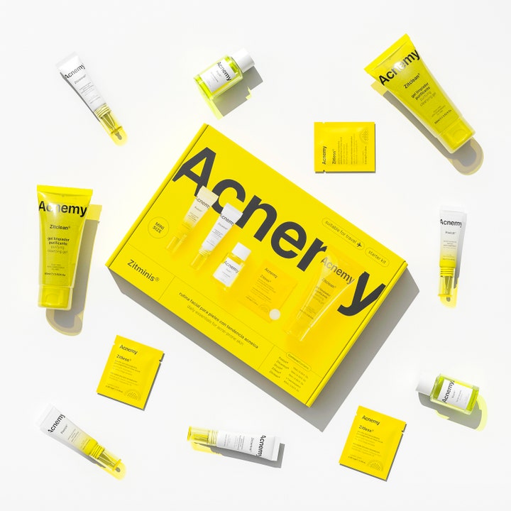 Niche Beauty Lab Acnemy Zitminis Discovery Kit til uren hud med gule og hvide tuber spredt omkring en gul æske.