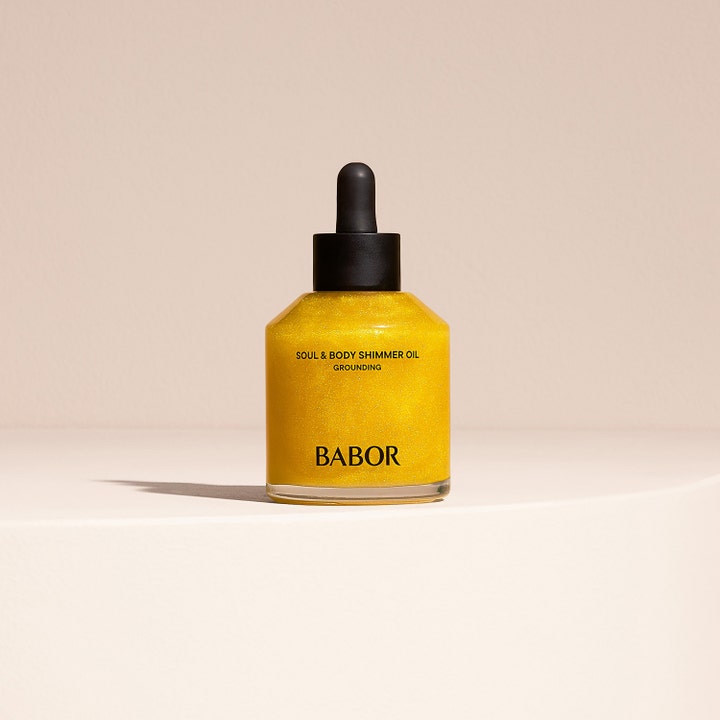 Babor Soul & Body Shimmer Oil 100 ml kropsolie giver glød i en klar glasflaske med sort pipette og glitrende guldolie