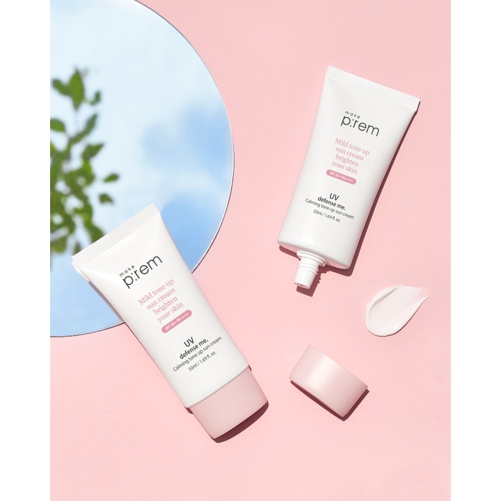 Make Prem UV Defense Me Calming Tone Up Sun Screen 50 ml solcreme med lyserød tekstur på en rosa baggrund.