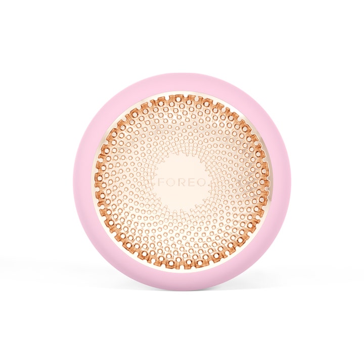 Foreo UFO 2 ansigtsmaske-apparat skaber glød i et rundt lyserødt design med en mønstret flade i rosaguld.