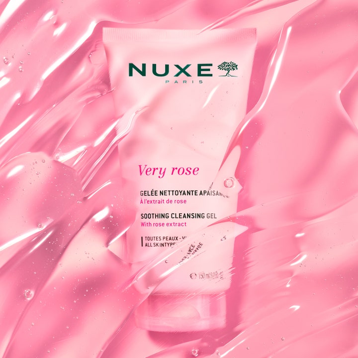Nuxe Very Rose Soothing Cleansing Gel 150 ml beroligende ansigtsrens i lyserød tube omgivet af en glinsende gelétekstur