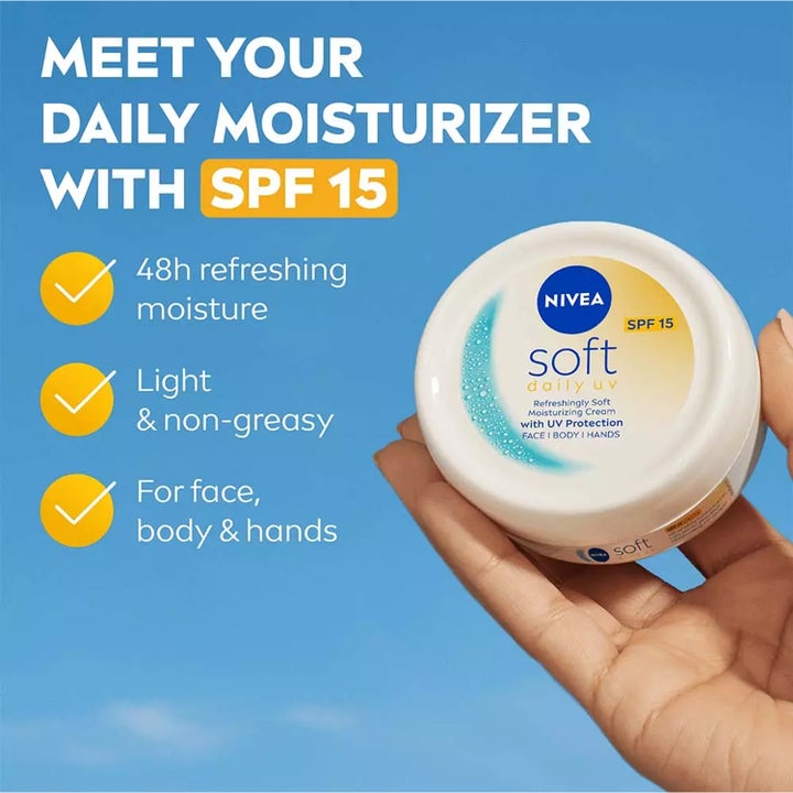 NIVEA Soft Daily UV Moisturizing Cream 100 ml SPF 15 fugtighedscreme i hvid krukke holdt af en hånd mod blå himmel.