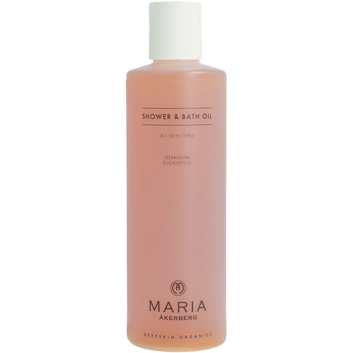 Maria Åkerberg Shower & Bath Oil 250 ml blødgørende badeolie i frostet plastflaske med hvidt låg og ferskenfarvet indhold.