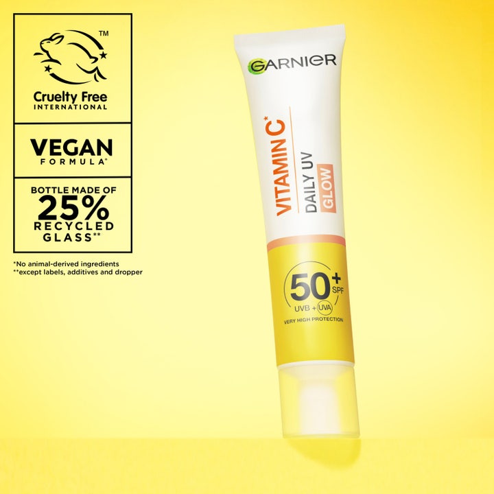 Garnier Skin Active Vitamin C Glow UV Fluid 40 ml SPF50+ mod mørke pletter vist i en hånd med en lille swatch.