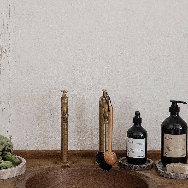 Meraki Forest Garden Clean Dishes 490 ml opvaskemiddel i mørk pumpeflaske i et rustikt køkkenmiljø.